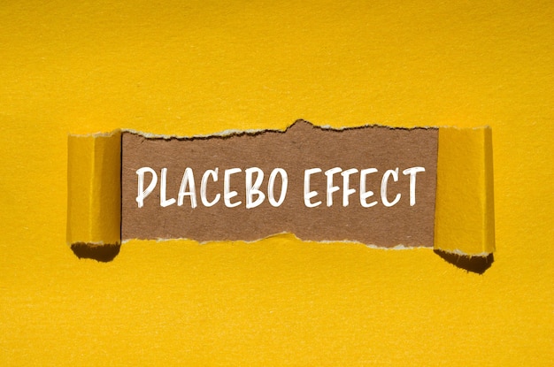 Parole con effetto placebo scritte su carta gialla strappata con sfondo marrone