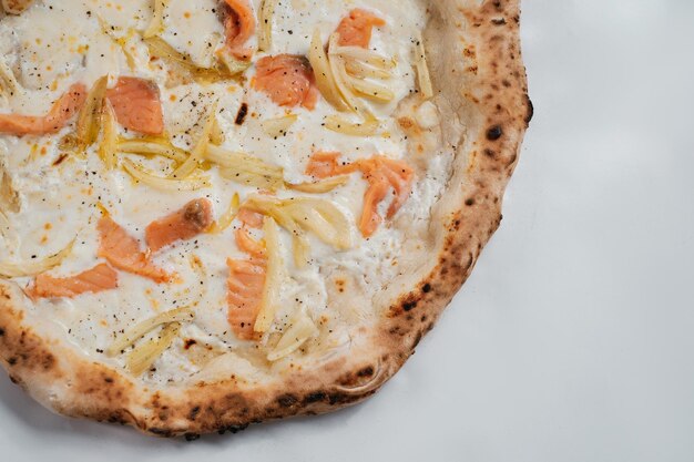 Foto pizza italiana con cipolle di formaggio e salmone su sfondo bianco