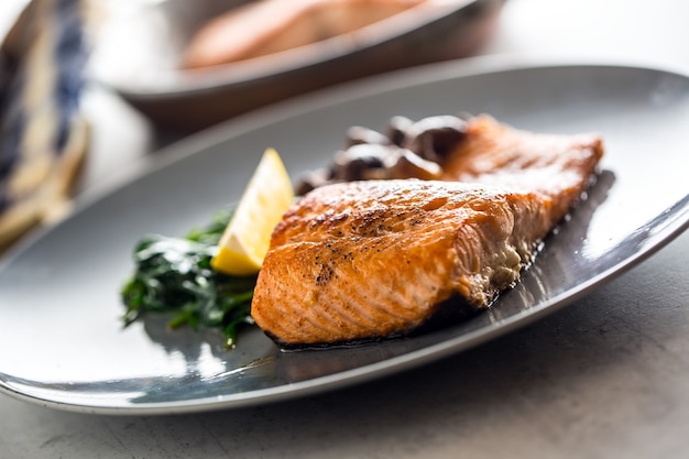 Porzione di filetto di salmone arrosto con funghi spinaci in ristorante pub casa o hotel