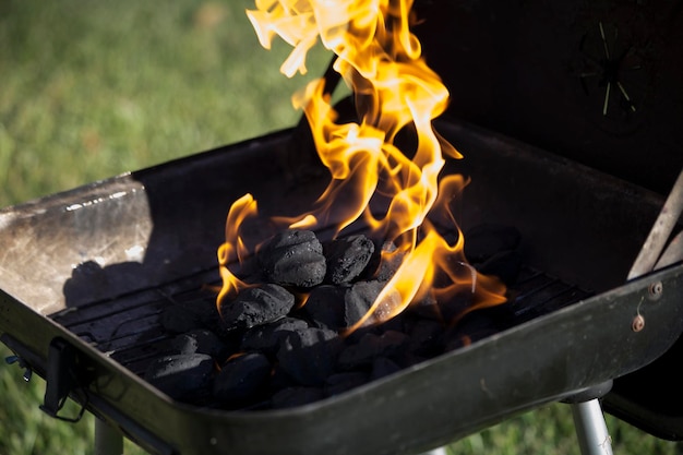 Foto prossimo piano del fuoco sulla griglia da barbecue