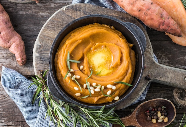 Purè di patate dolci piccanti o purè di patate dolci con rosmarino in una casseruola su un tavolo