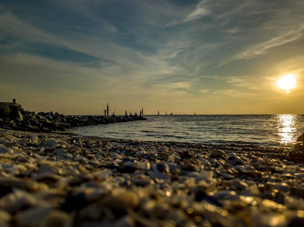 Tramonto in spiaggia con persone che pescano