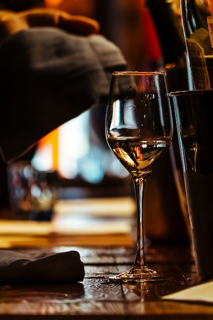 Un bicchiere di vino sul tavolo di legno del ristorante.