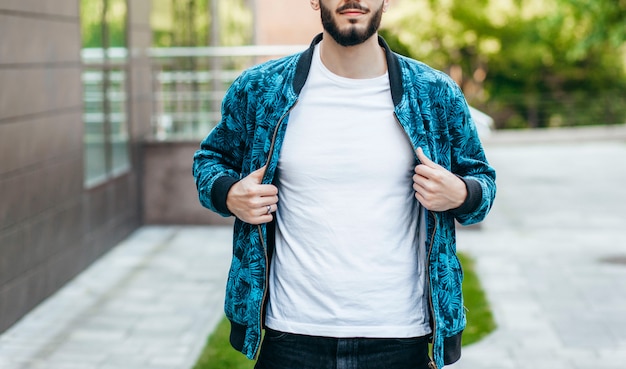 Foto un giovane uomo alla moda con la barba in una maglietta bianca e occhiali da sole