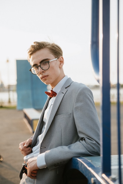 Foto un uomo in abito grigio posa per strada per pubblicizzare abiti da uomo.