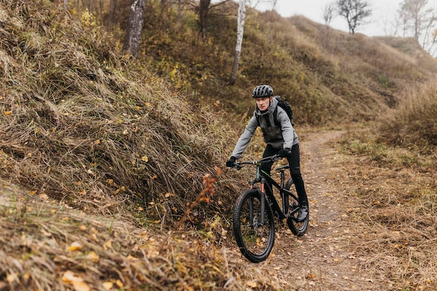 Uomo in sella a una bicicletta sul sentiero di montagna