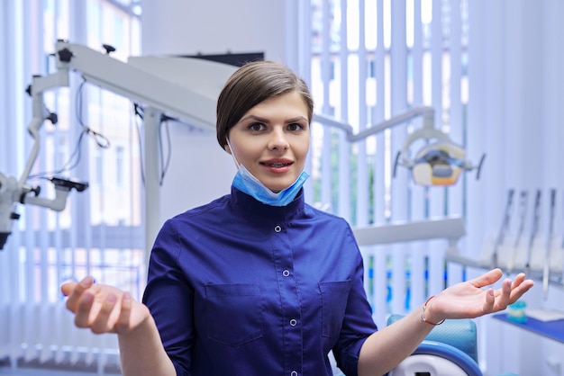 Videochiamata, telemedicina, videoconsulenza sul sito, moderne tecnologie in medicina odontoiatrica. Dentista dottoressa che parla guardando la webcam, primo piano, sfondo dell'ufficio della clinica odontoiatrica