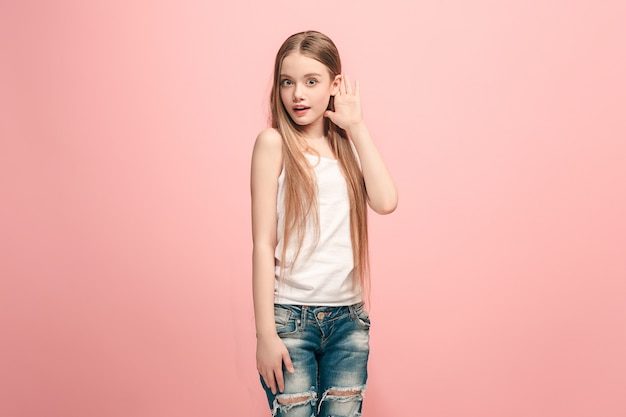 Foto grátis a adolescente feliz em pé e ouvindo no estúdio rosa da moda