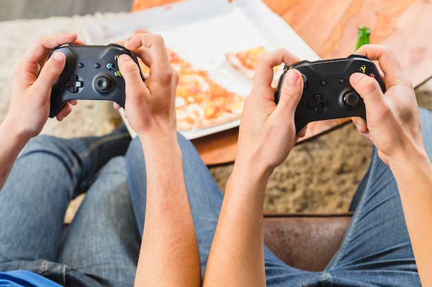 Foto grátis amigos comendo pizza e jogando no console