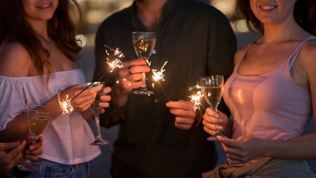 Amigos próximos posando com fogos de artifício