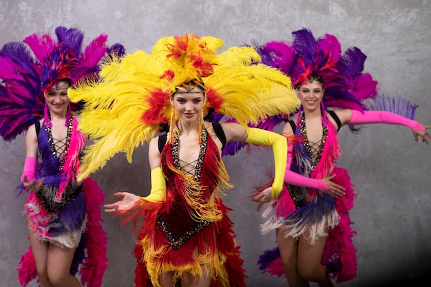 Foto grátis artistas de cabaré feminino dançando nos bastidores em trajes de penas