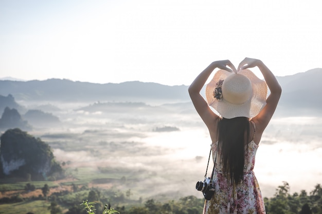 Foto grátis as mulheres mostram gestos em forma de coração no ponto de vista da montanha.