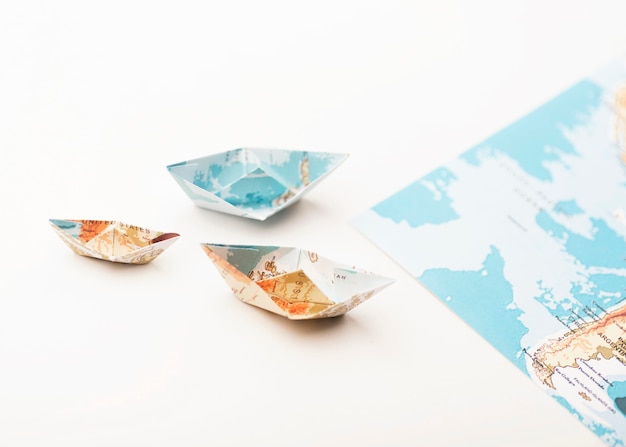 Foto grátis barcos pequenos de papel de grande ângulo com mapas do mundo