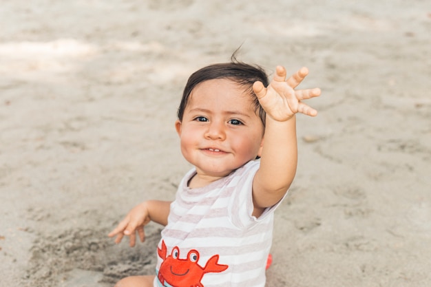 Bebê feliz sentado na areia