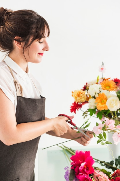 Foto grátis belo florista feminino flor corte haste com uma tesoura