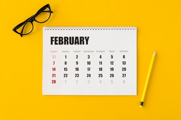 Foto grátis calendário do planejador de camada plana em fundo amarelo