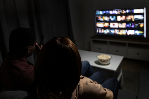 Foto grátis casal assistindo serviço de streaming juntos em casa dentro de casa