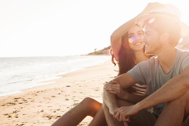 Casal sentado ao lado do mar em um lindo dia