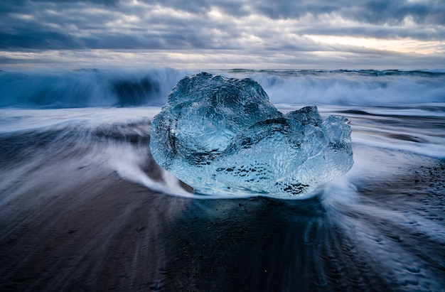 Foto grátis closeup tiro de uma lagoa glaciar na islândia com um mar ondulado ao fundo