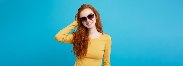 Foto grátis conceito de viagem close up retrato jovem linda atraente roxa cabelo vermelho garota com óculos de sol da moda sorridente azul pastel fundo espaço de cópia