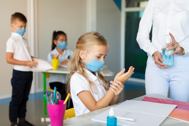 Crianças desinfetando as mãos antes da aula