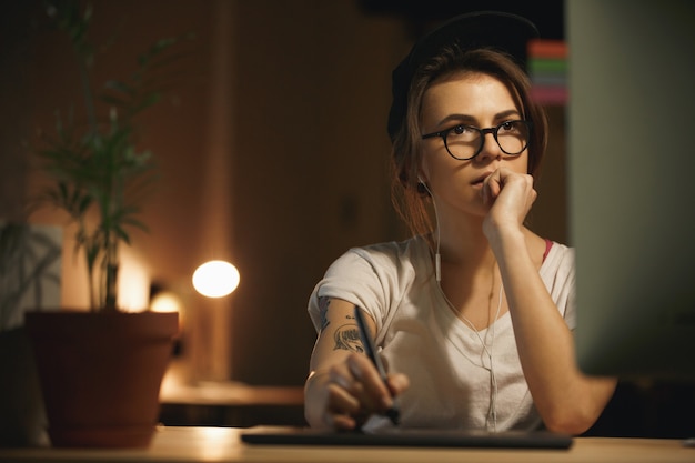 Foto grátis designer de mulher concentrada usando mesa digitalizadora e computador]