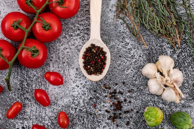 Foto grátis diferentes tipos de vegetais com pimenta na colher de madeira no fundo de pedra