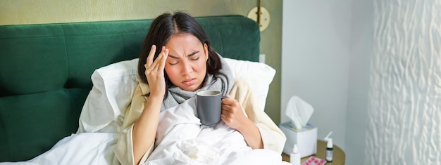 Foto grátis doença de gripe e pessoas jovens se sentindo doentes, com febre e pegando col deitada na cama com calor