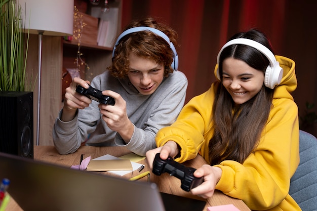 Foto grátis dois amigos adolescentes jogando videogame juntos em casa