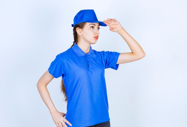 Foto grátis empregada de entrega de mulher em uniforme azul em pé e posando.