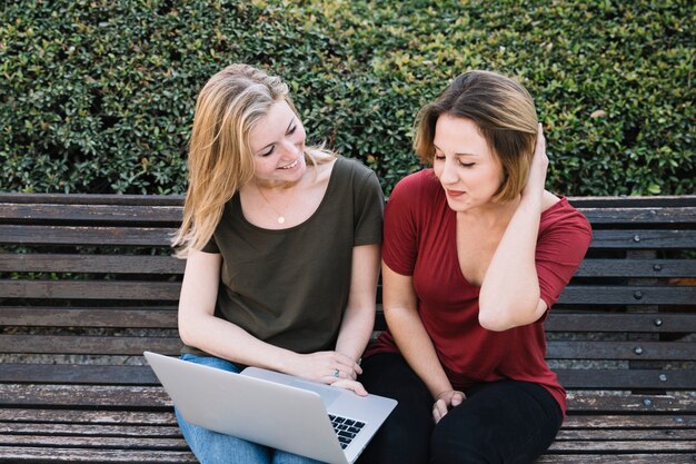 Encantadora mulher usando laptop no parque