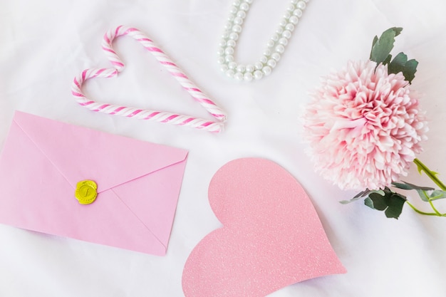 Foto grátis envelope com grande coração de papel rosa na mesa