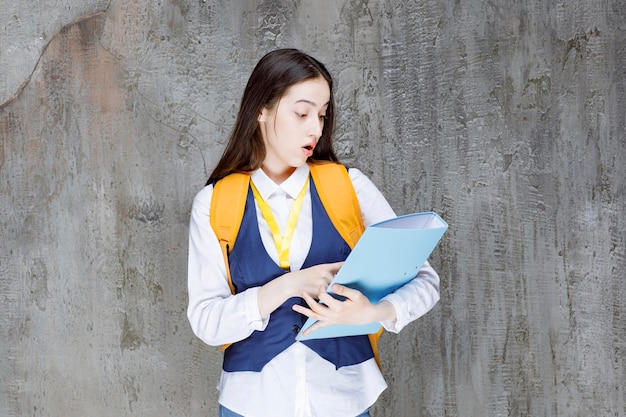 Estudante universitário de uniforme com pasta em pé. Foto de alta qualidade