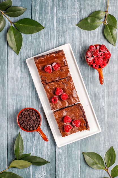 Foto grátis fatias de sobremesa de bolo de brownie de chocolate com framboesas e especiarias, vista superior