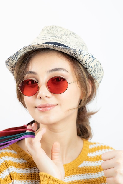 Foto grátis feche a foto da jovem morena em óculos de sol segurando sacolas coloridas. foto de alta qualidade