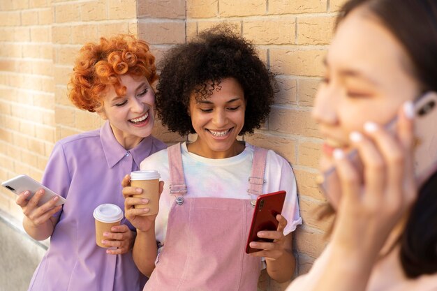 Feche amigos sorridentes com smartphones