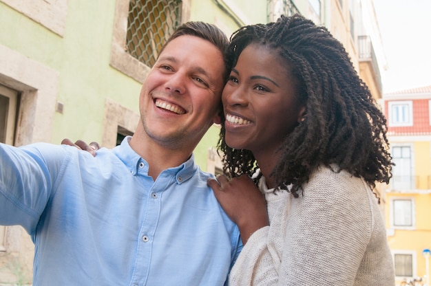 Foto grátis feliz casal intercultural sonhador desfrutando de encontro romântico na cidade