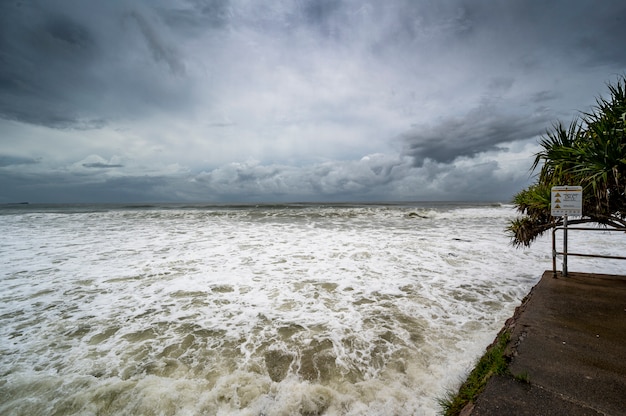 Foto grátis ferida espumosa sob céu escuro e nublado em alexandra headland beach, queensland, austrália