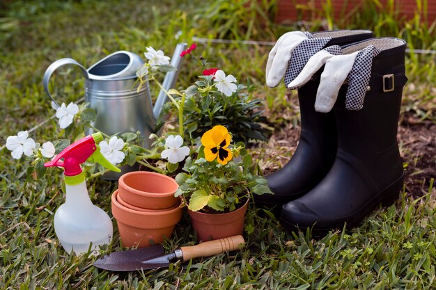 Ferramentas de jardinagem e flores no chão