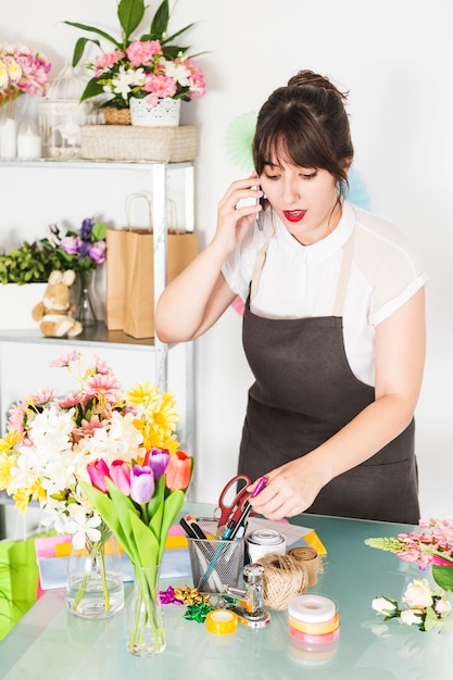 Foto grátis florista feminina falando no celular na loja floral