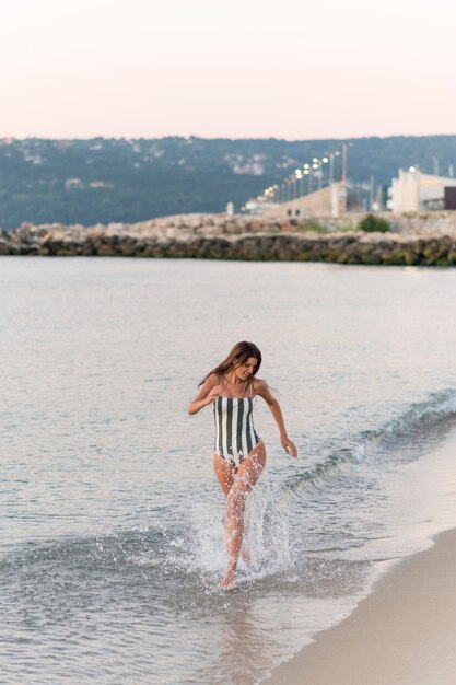 Foto completa de uma linda garota na praia