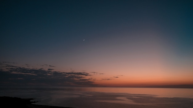 Foto grátis foto incrível de uma bela paisagem marinha em um pôr do sol laranja