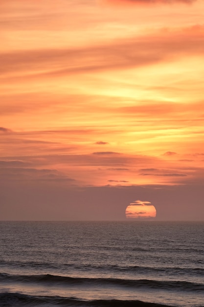 Foto grátis foto vertical de um cenário de pôr do sol de tirar o fôlego sobre o oceano