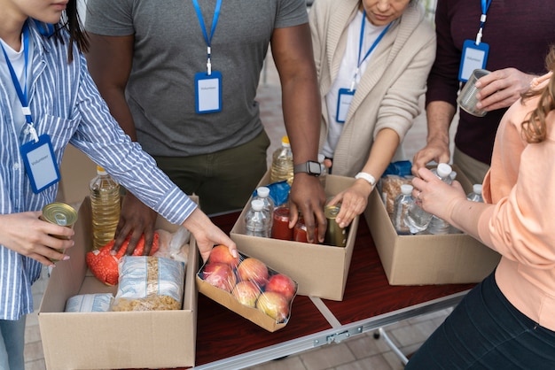 Foto grátis grupo de diferentes pessoas oferecendo-se como voluntário em um banco de alimentos para pessoas pobres