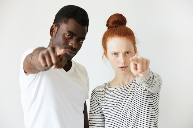 Foto grátis homem africano com camiseta branca e mulher caucasiana ruiva com top listrado