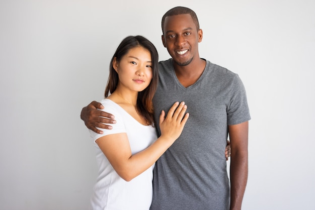 Foto grátis homem africano novo de sorriso que abraça sua amiga asiática.