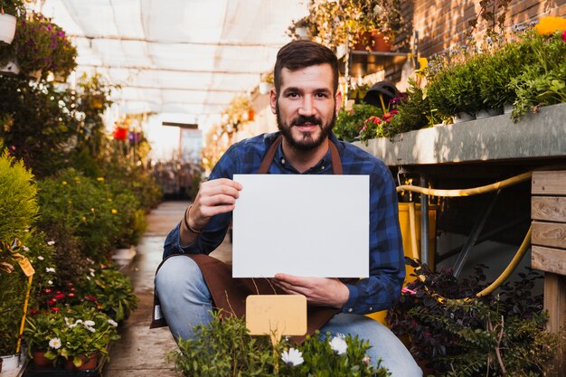 Homem com folha de papel perto de flores