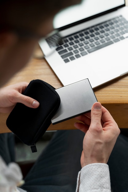 Foto grátis homem de alto ângulo segurando ssd e capa