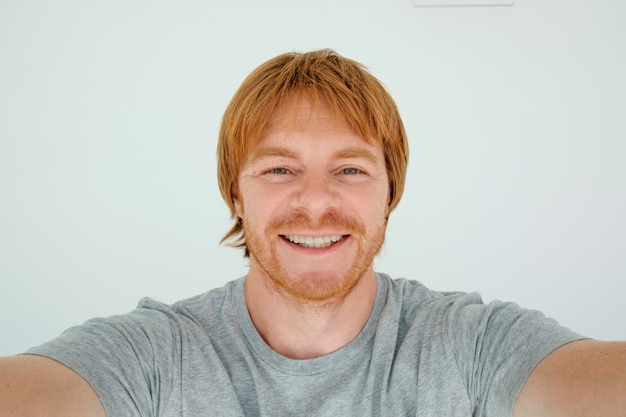 Homem de cabelo vermelho feliz tomando foto de Selfie