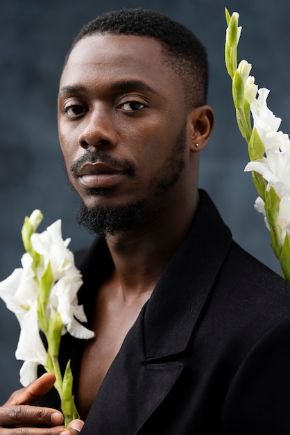 Foto grátis homem de tiro médio posando com flores